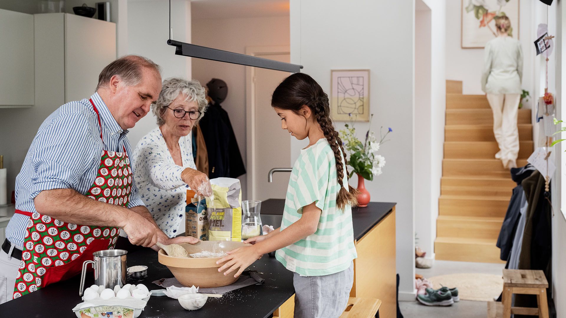 Piger bager med bedsteforældre i køkkenet, hvor indboforsikringen også dækker. 