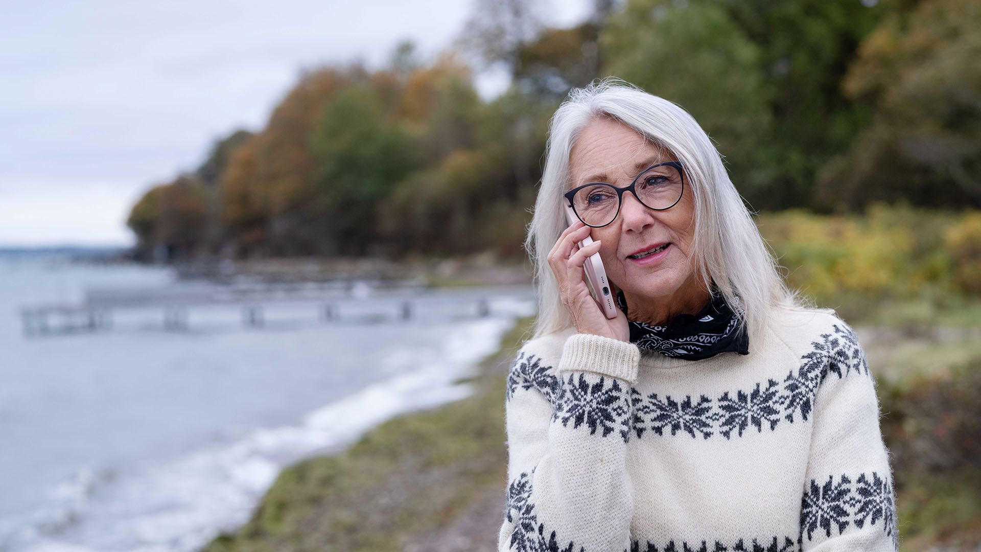 Kvinde taler i telefon på stranden